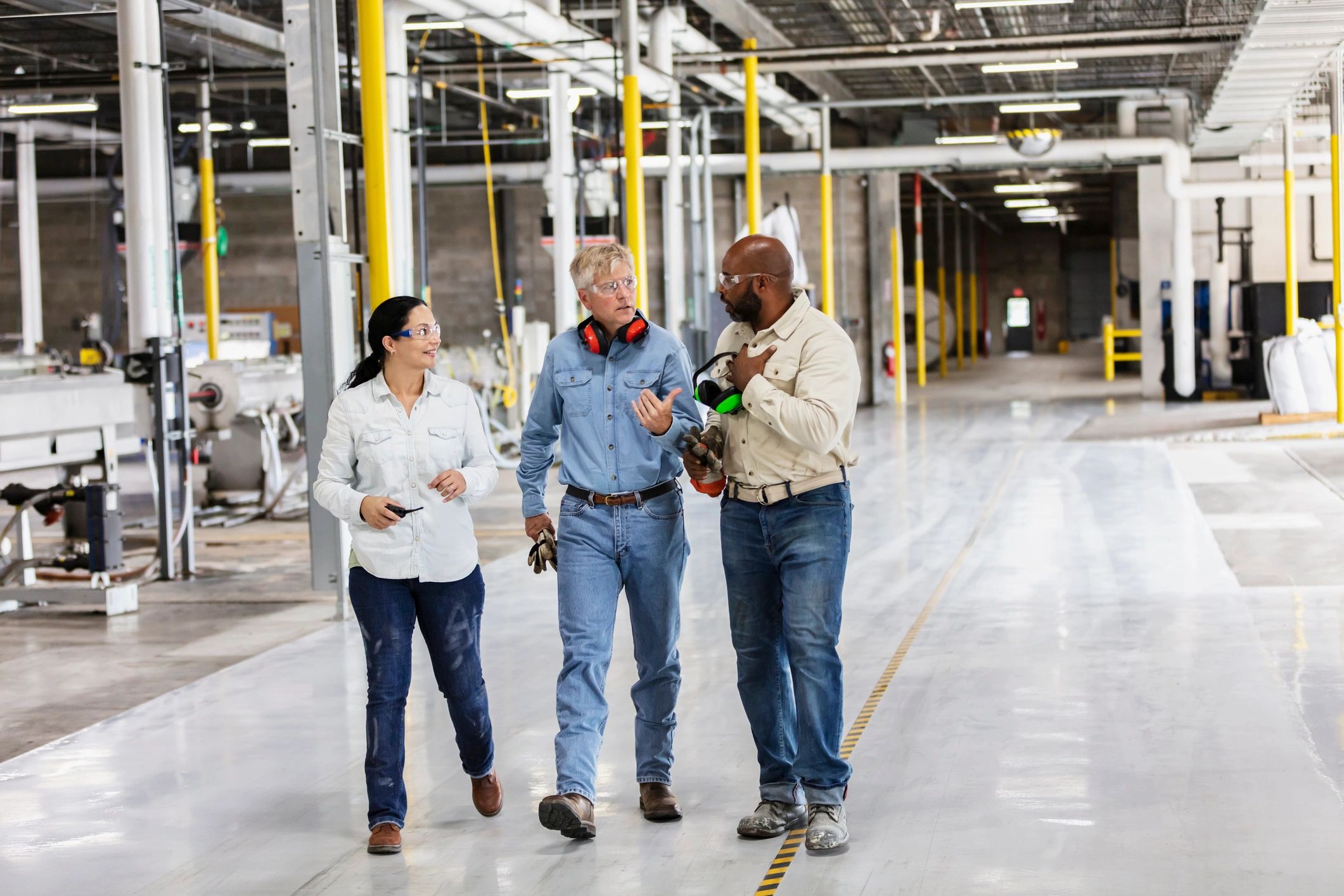 Factory workers walking and talking on the production floor