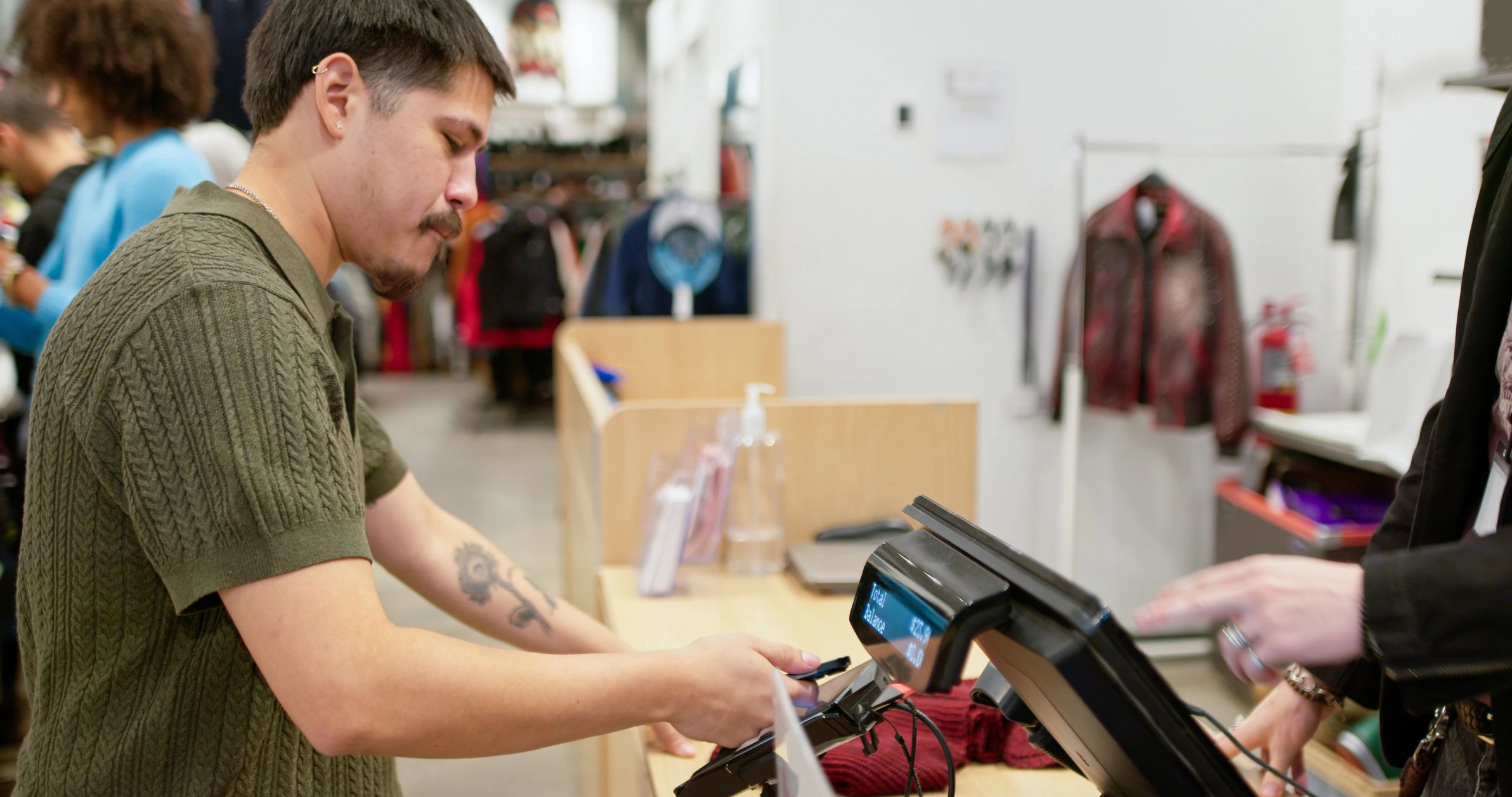 Customer making a contactless payment at a clothing store checkout