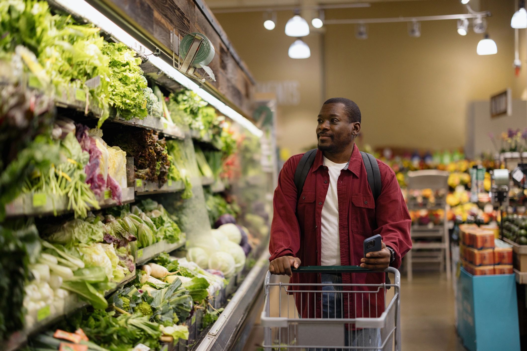Worker in a supermarket aisle with stocked shelves