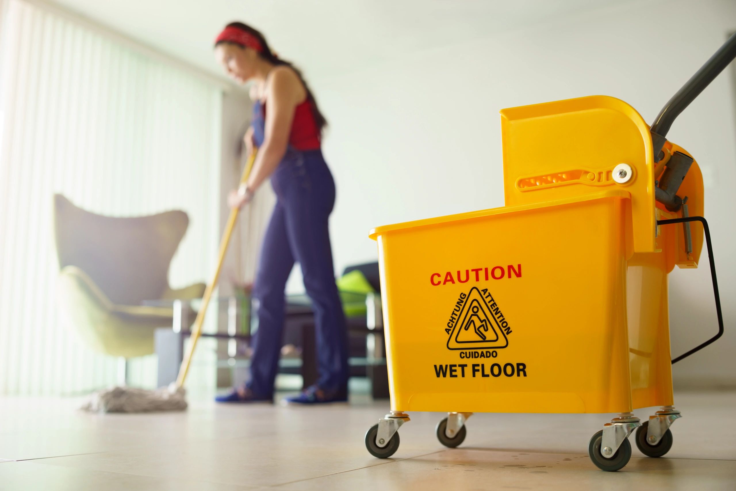 Cleaner mopping a floor indoors